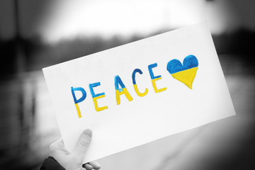 Hand holding paper with Peace of Ukraine