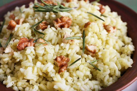 Rice with walnuts and rosemary in plate, macro