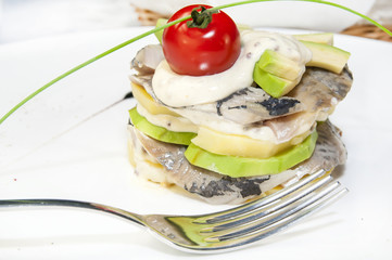 Herring salad with avocado sauce on a plate in a restaurant