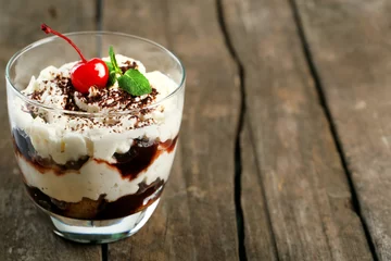  Tasty tiramisu dessert in glass, on wooden background © Africa Studio