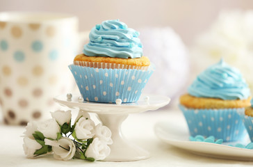 Delicious cupcakes on table on light background