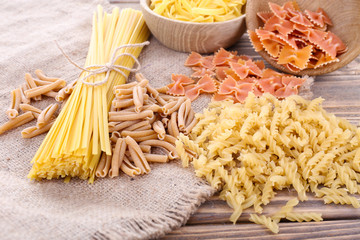 Different types of pasta on sackcloth background