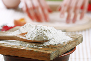 Young woman prepares dough on table close up