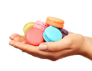 Tasty colorful macaroons in female hands isolated on white