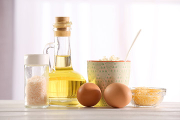 Different products on wooden table on blurred window background