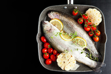 raw fish with vegetables in pan