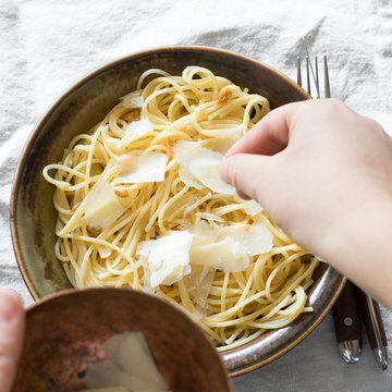 Spaghetti with Oil and Garlic Being Served with Parmesan
