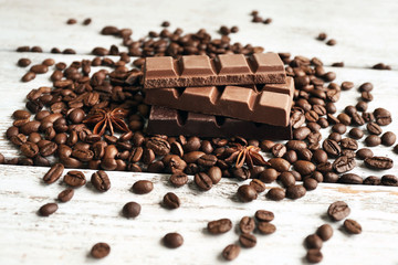 Chocolate with star anise and coffee beans on wooden background