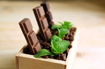 Still life with set of chocolate in wooden box of coffee grains