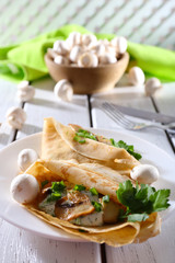 Pancakes with creamy mushrooms and greens in plate