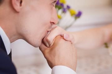 groom kissing bride's hand