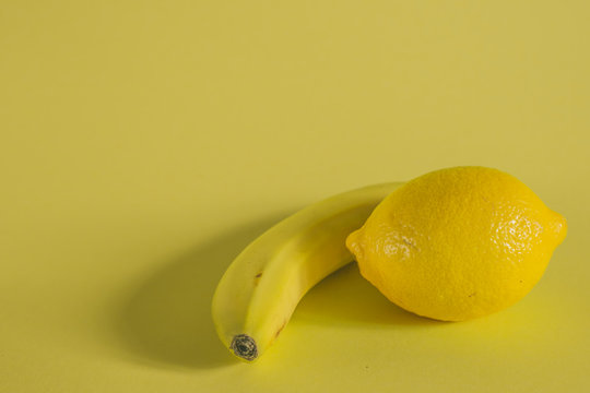 banana and lemon on yellow background