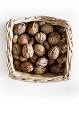 walnuts in the basket isolated on white, view from top
