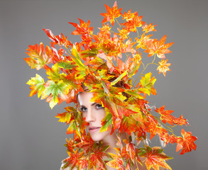 Beautiful young woman wrapped in leafs