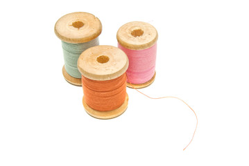 three wooden spools of thread
