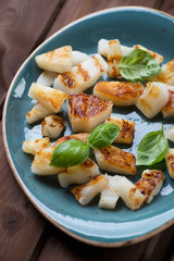 Close-up of grilled pineapple slices with green basil leaves