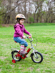 little girl learning to ride a bicycle