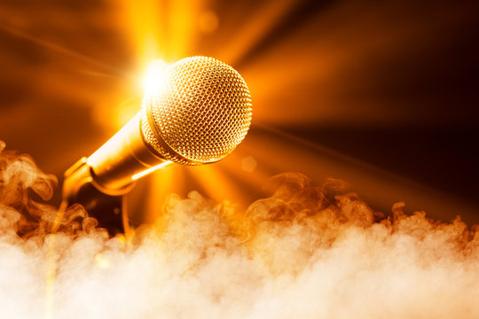 golden microphone on stage with smoke