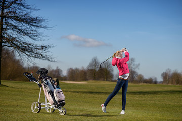 Junge schlanke Frau spielt einen Annäherungsschlag beim Golf