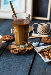 coffee with milk in a glass with biscuits and chocolates