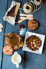 coffee with milk in a glass with biscuits and chocolates, a top