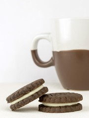 Chocolate biscuits with a milk cream filling and coffee cup