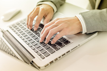 Fototapeta na wymiar Closeup of businessman hands typing on laptop computer