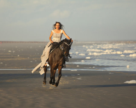 woman riding horse on beach