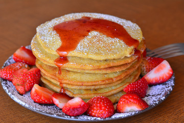 Stack of sweet pancakes with strawberry and icing sugar