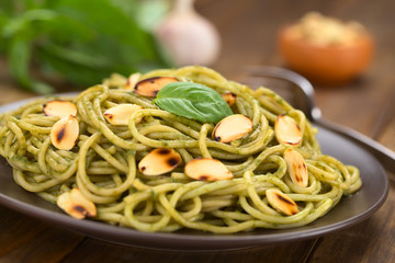 Pasta with pesto made of basil and spinach garnished with almond