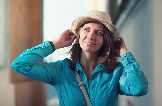 Beautiful young hipster woman in hat and blue jacket