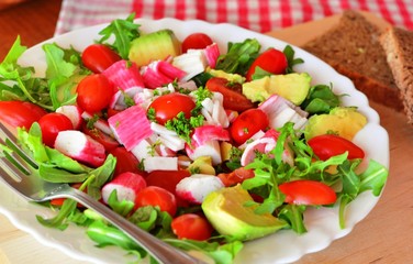 Mixed vegetable salad with crab sticks and avocado