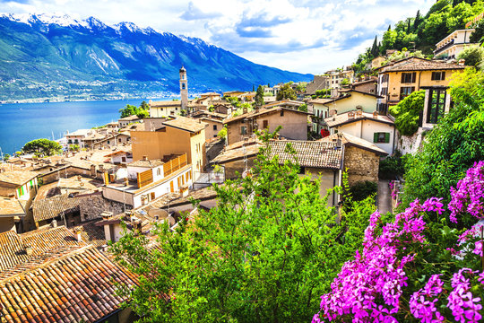 Limone sul Garda Italy. Scenic View with Pink Flowers and Lake Garda Background. Traditional Italian Village Architecture Alps Mountains. Waterfront Landscape Scenic Travel Destination 