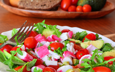 Mixed vegetable salad with crab sticks and avocado