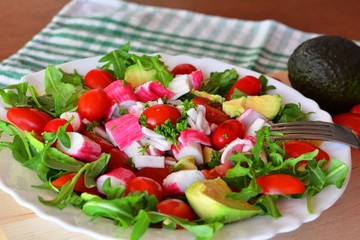Mixed vegetable salad with crab sticks and avocado