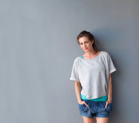 Charming woman standing against gray background in shorts
