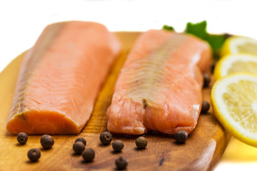 Raw salmon fillet with lemon, black pepper and parsley