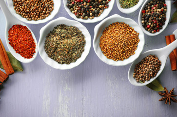 Different kinds of spices in ceramics bowls and spoons