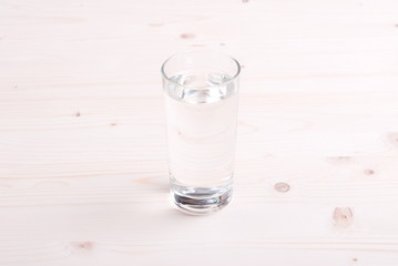 water in a glass and a napkin on the board