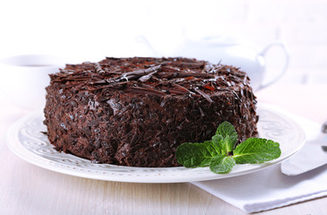 Tasty chocolate cake with cup of tea on table close up