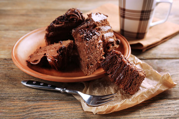 Slices of tasty chocolate cake on plate on table close up