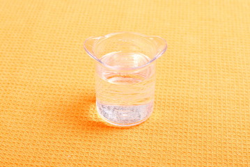 water in a glass and a napkin on the board