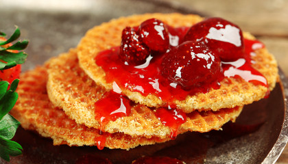 Wafers with strawberry jam and berries on tray close up