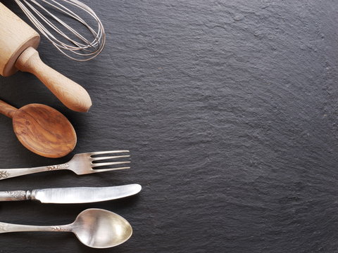 Cooking utensils on a dark grey background.
