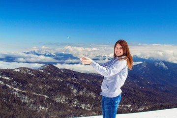 Naklejka premium Девушка, играющая со снегом на фоне красивых гор