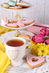 Fototapeta na wymiar Composition of spring flowers, tea and cookies on table