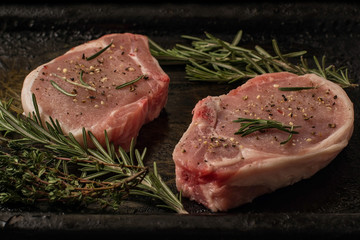 Raw pork steaks on the old iron tray
