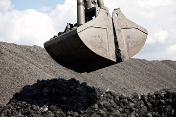 Coal loading excavator, heaps of coal