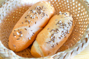 Two bread rolls with salt and caraway in a rustic basket