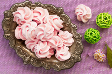 Pink meringue on antic plate, top view